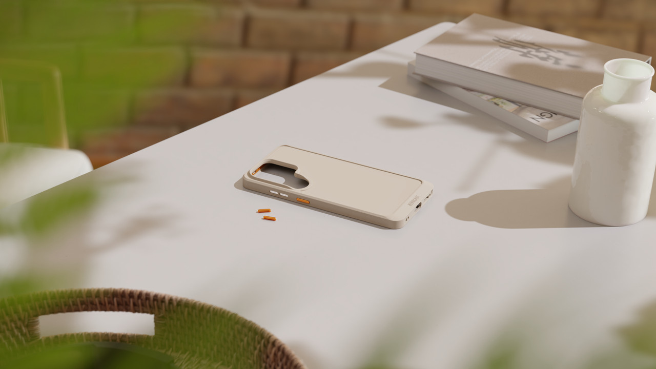 Beige smartphone case with interchangeable orange buttons on a table.