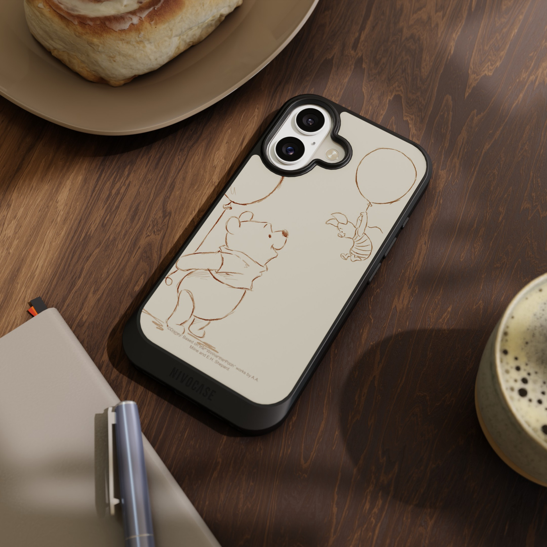 Étui pour téléphone portable NIVOCASE avec un motif automnal de Winnie l'ourson, posé sur une table.